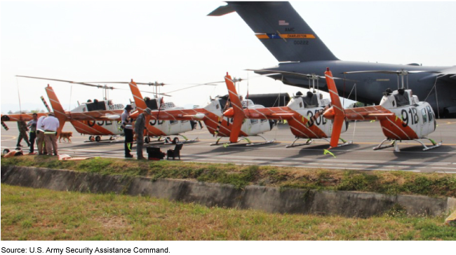 A line of helicopters parked on a runway