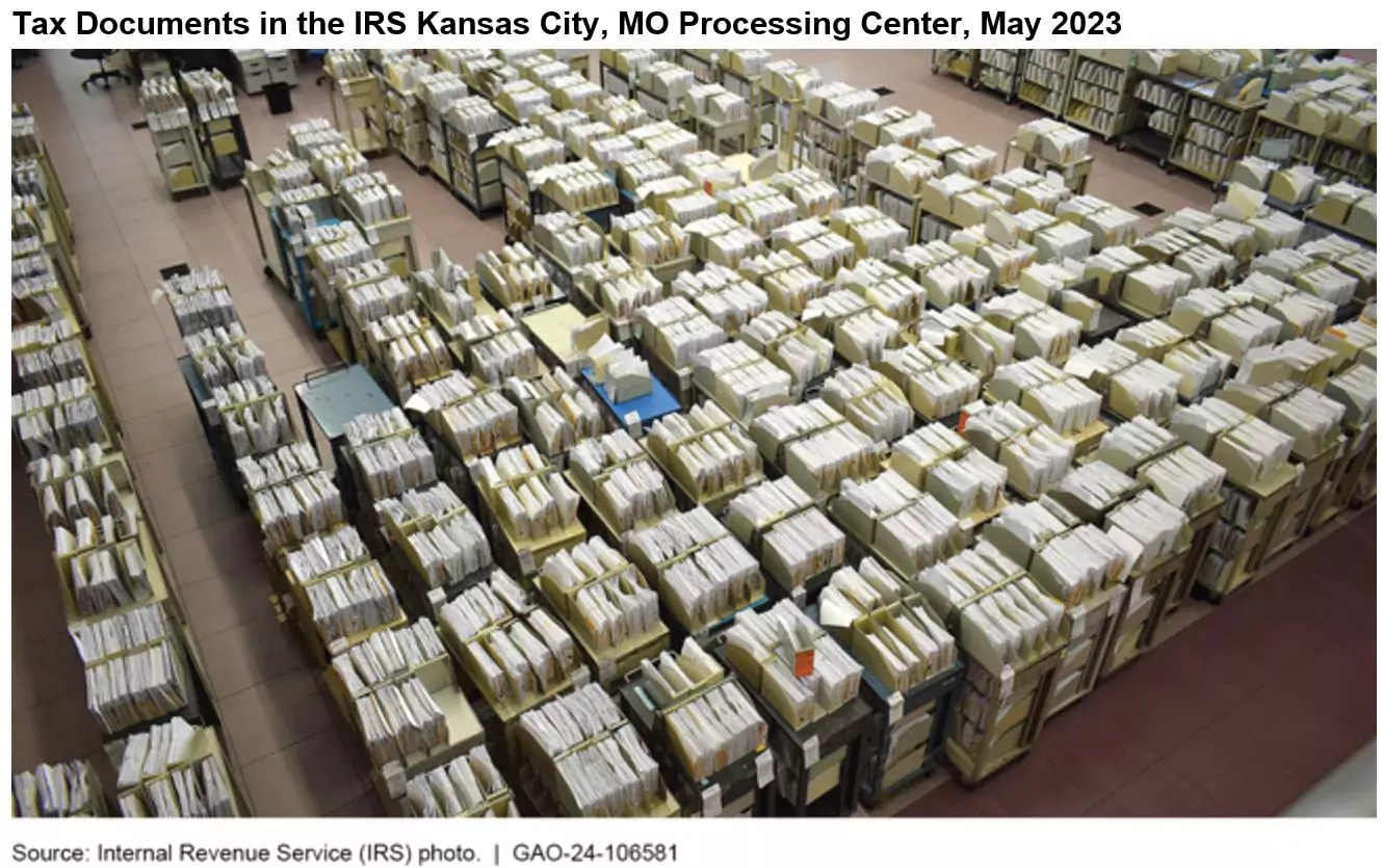 Photo showing tax documents (files on roller carts) in a large room at the IRS's Kansas City, MO processing center in May 2023