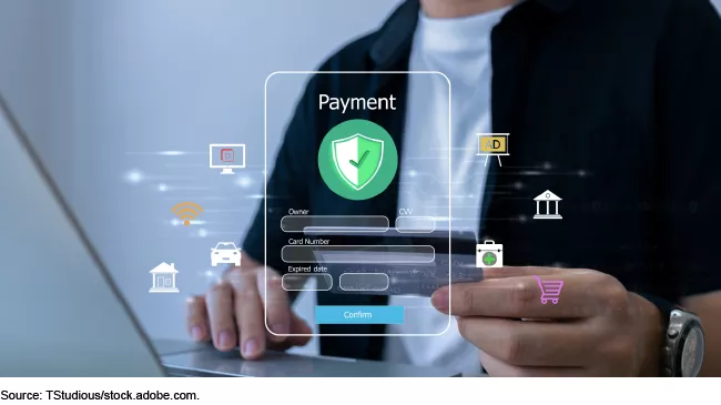 Stock image showing someone on their laptop putting in a credit card information.